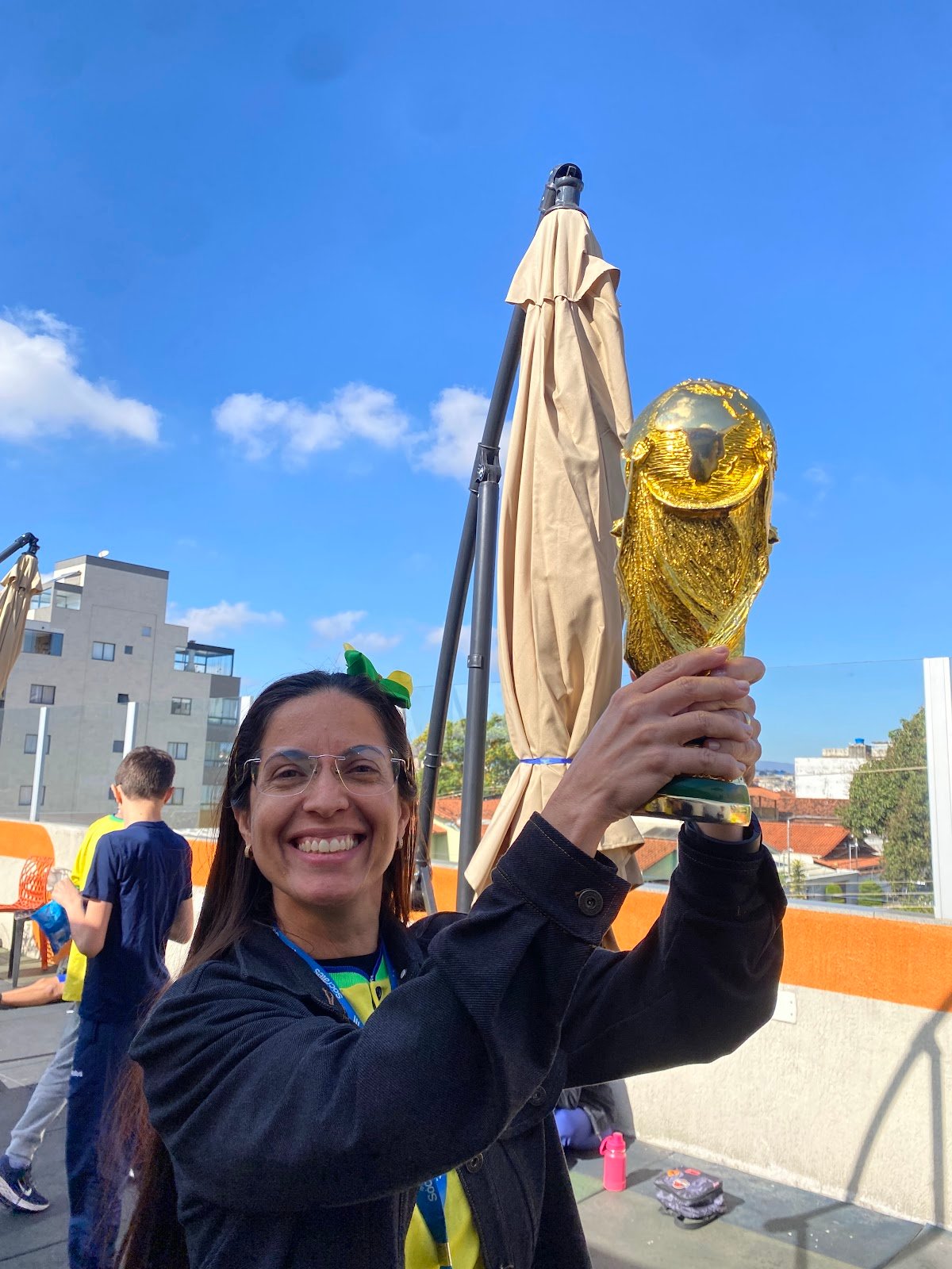 Professora do Colégio Sócrates comemorando com a taça da Copa do Mundo