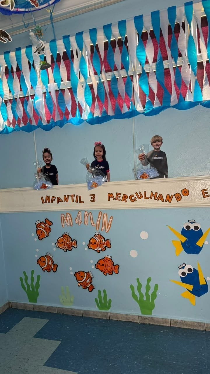 Sala do Infantil 3 decorada com Nemo e Dory, com fotos das crianças segurando saquinhos com peixinhos no alto da parede