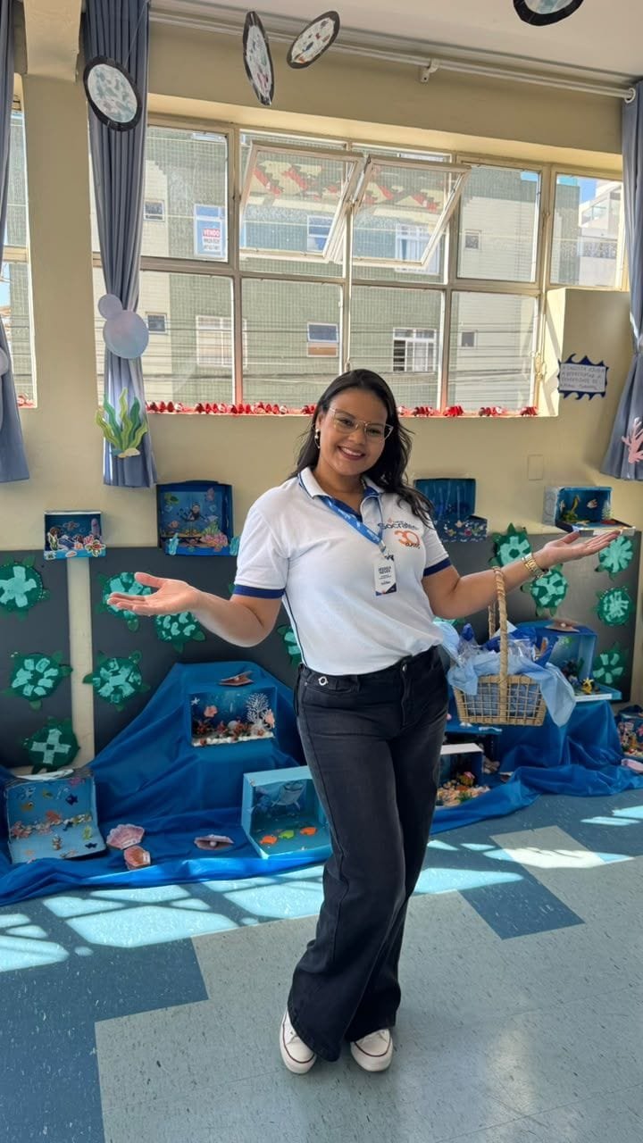 Educadora do Colégio Sócrates apresentando a sala decorada com o tema fundo do mar