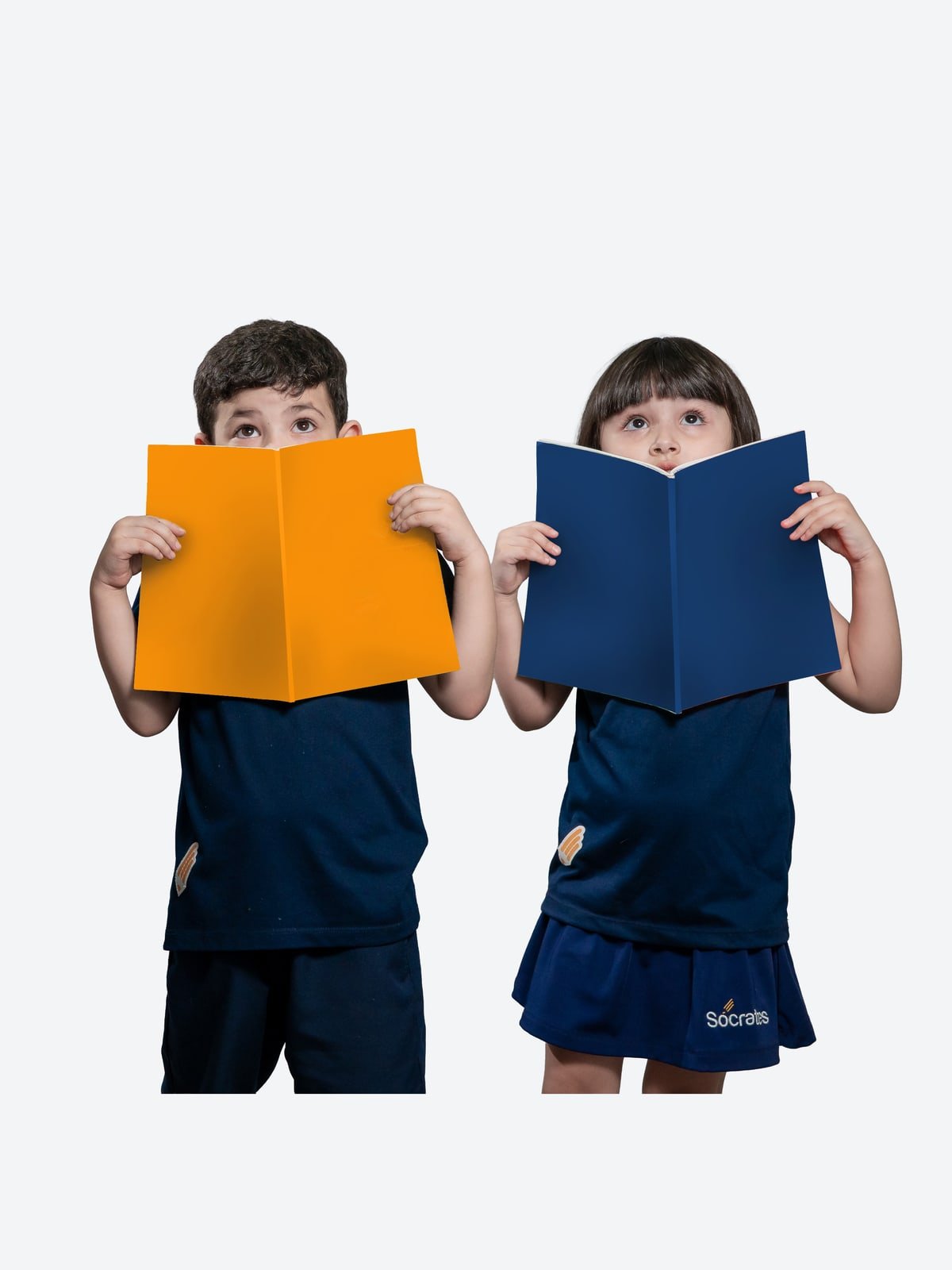 Dois alunos do Colégio Sócrates espiando curiosos por cima de livros abertos